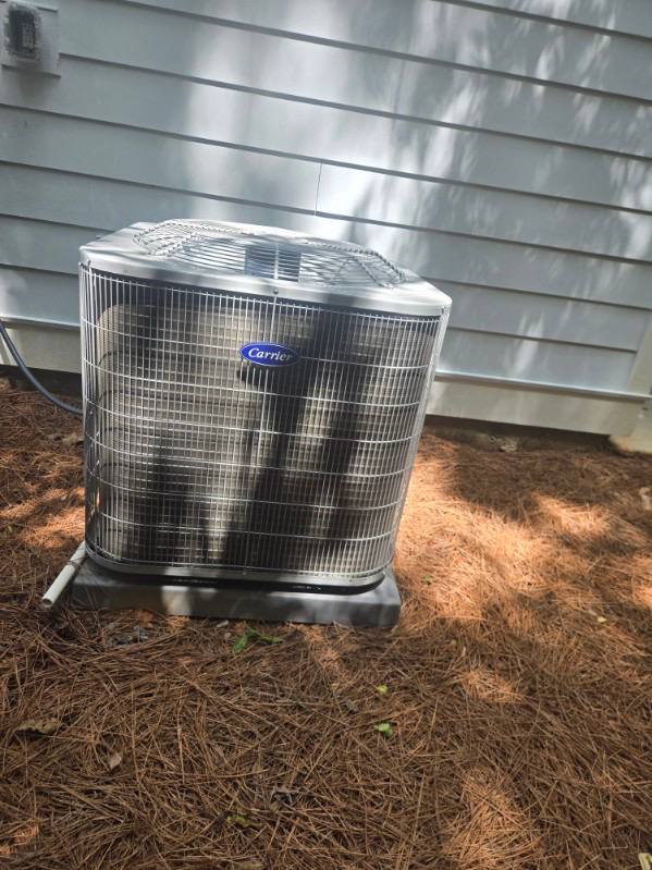 Carrier outdoor air conditioning unit beside a home