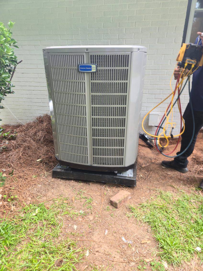 Technician servicing an outdoor HVAC unit
