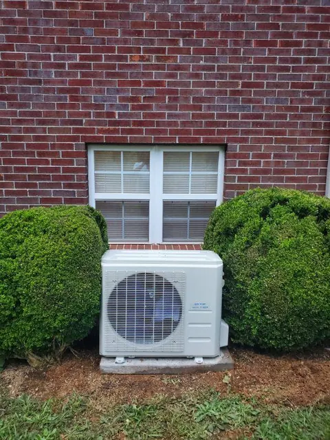 Outdoor mini-split system beside a brick home