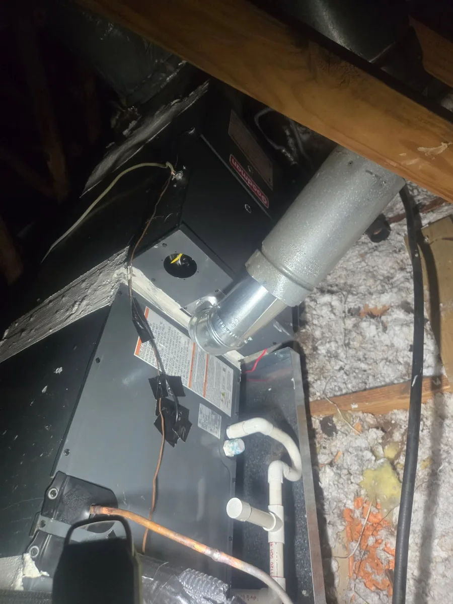 Goodman attic air handler with flue pipe, refrigerant line, and condensate drain piping